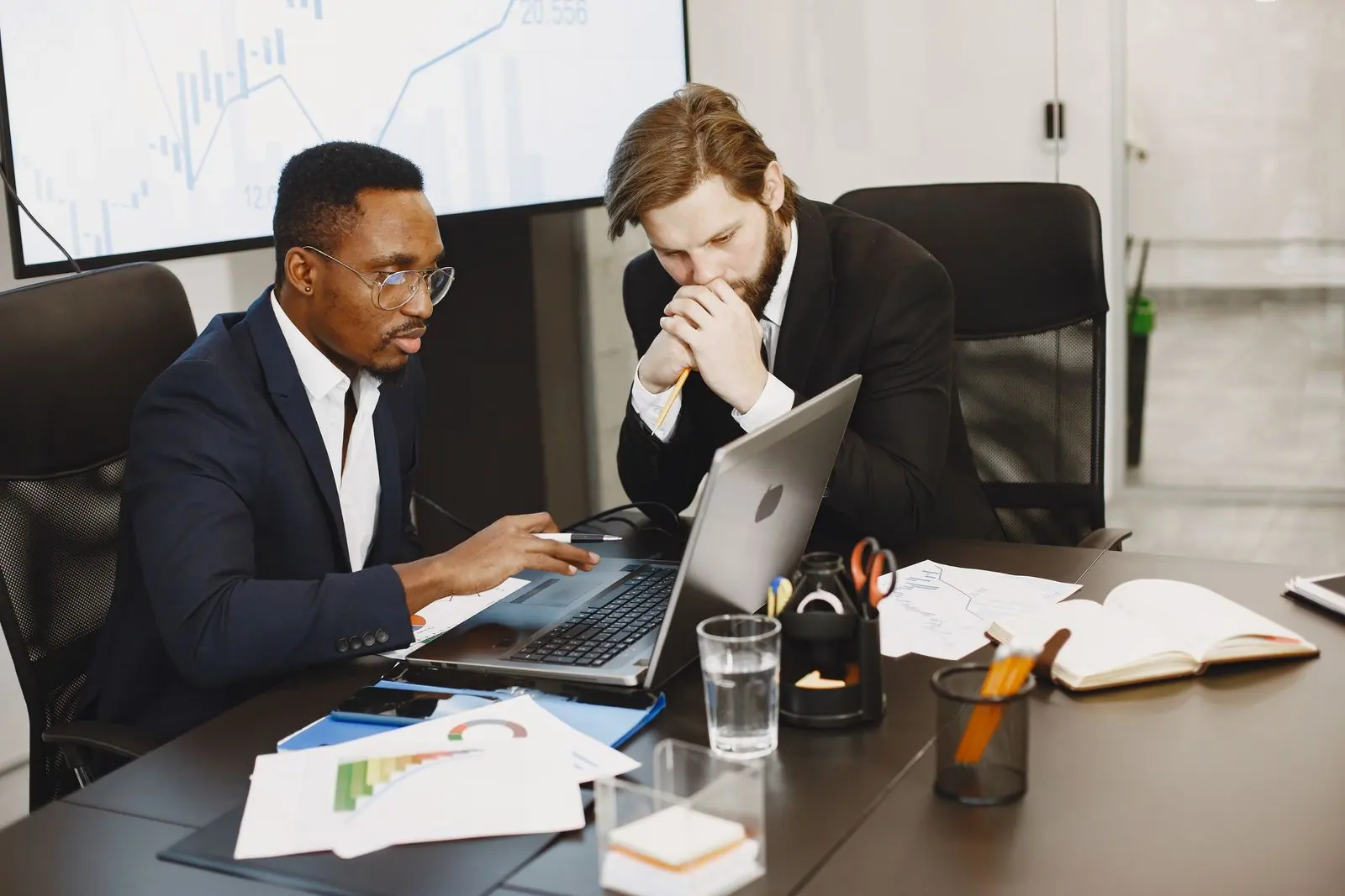 Representative buyers comparing supplier quotes on a laptop in an office