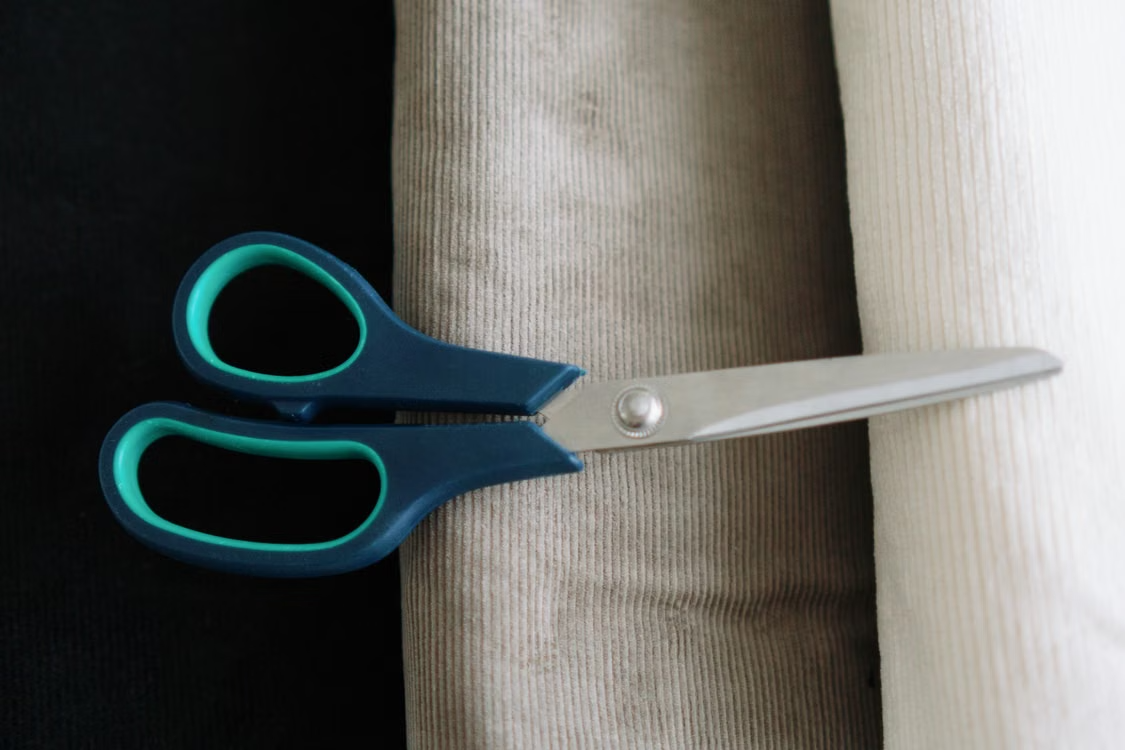 Scissors placed across folded fabric swatches during an apparel sample review