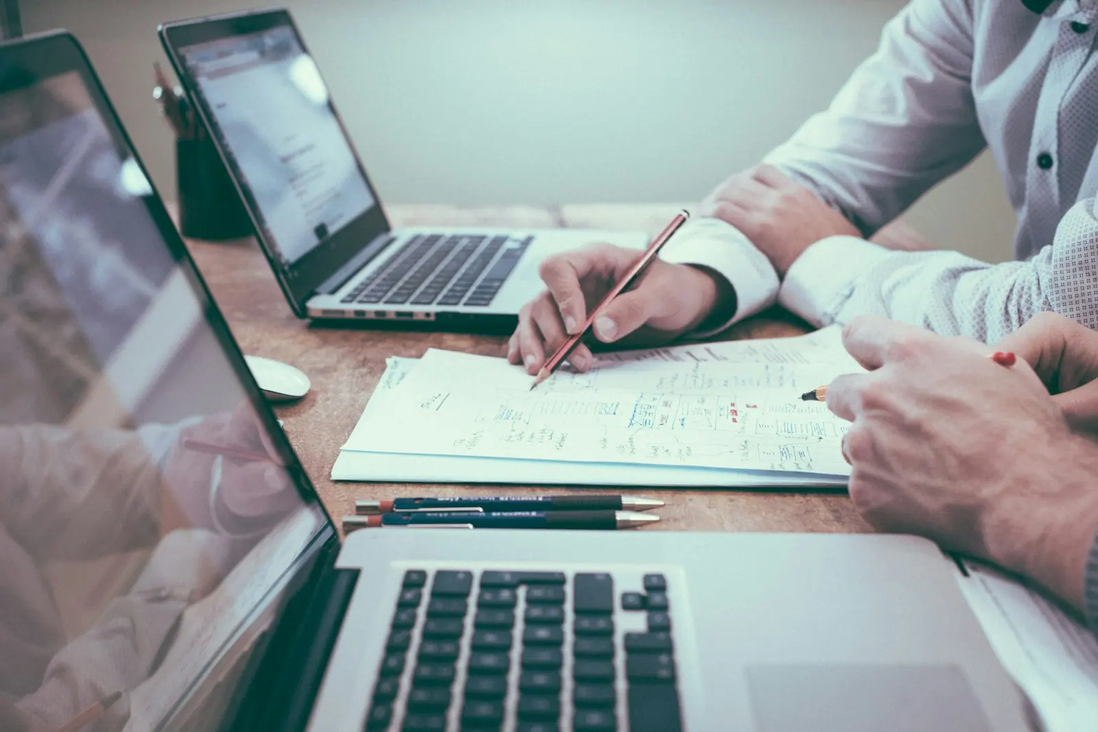 Representative people reviewing cost documents and a calculator at a desk