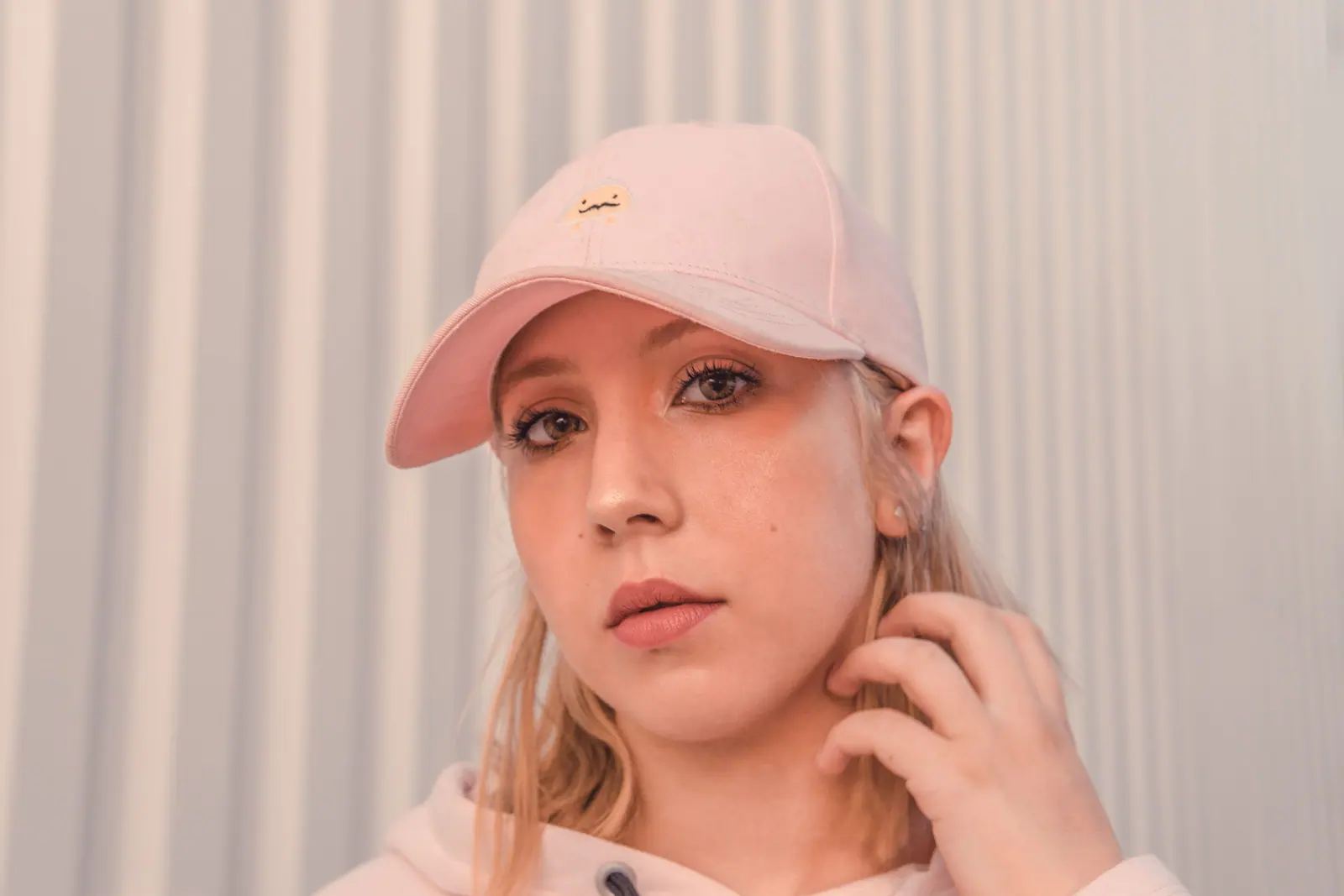 Woman wearing a pink baseball cap in a close-up portrait