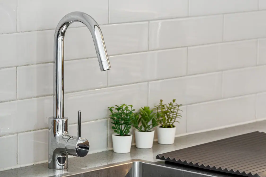 Chrome kitchen faucet and sink shown as a kitchen hardware reference