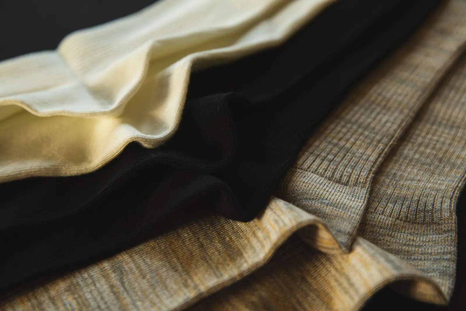 Black, cream and grey knitted socks arranged in a close-up textile detail