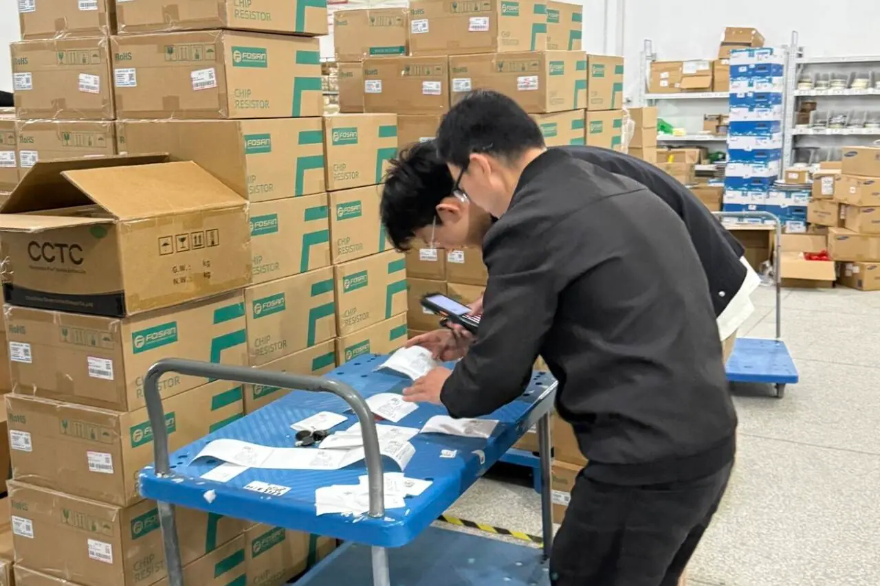Team checking labels and product documents beside packed cartons